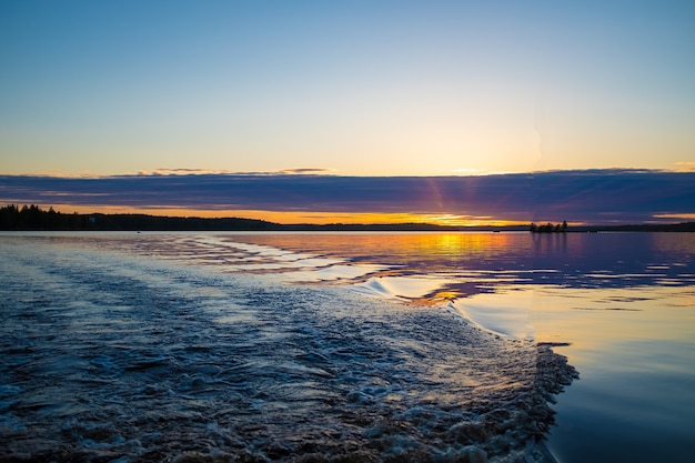 Superfície da água da natureza. lago ao pôr do sol com raios solares.