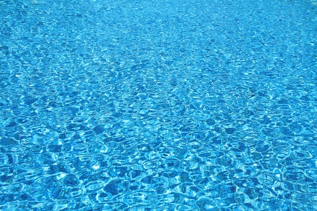 Superfície da água rasgada azul na piscina.