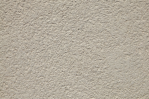 Superfície da parede com gesso texturizado bege.