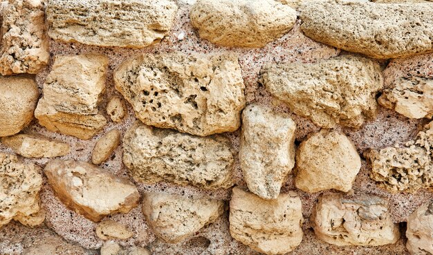 superfície da parede de pedra do castelo feita de pedras de diferentes formas, tamanhos e texturas