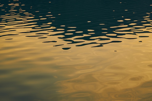 Superfície de água de fundo abstrato refletindo o papel de parede de sol com ondulações de forma de ondas