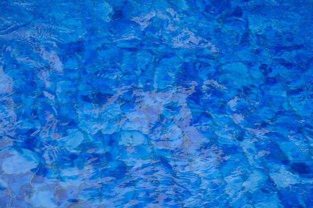 superfície de água limpa na piscina com azulejos azuis. projeto de piscina tropical.