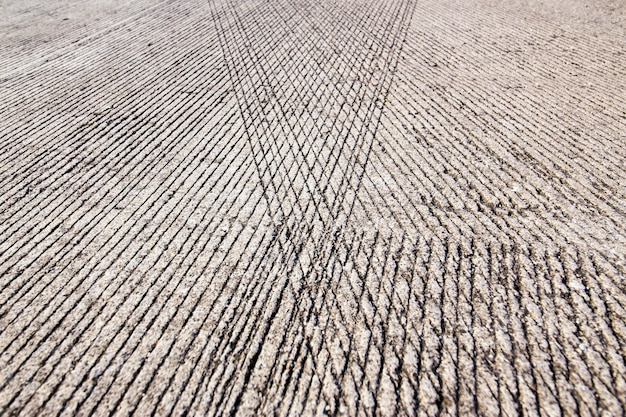 Superfície de estrada de concreto com linhas de resistência de derrapagem como plano de fundo