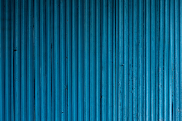 Superfície de madeira pintada em relevo fachada de madeira azul do edifício com rachaduras e pequenos defeitos