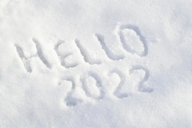 Superfície de neve e inscrição de texto "Olá" desenhadas na neve branca vista superior do conceito de feliz ano novo acima