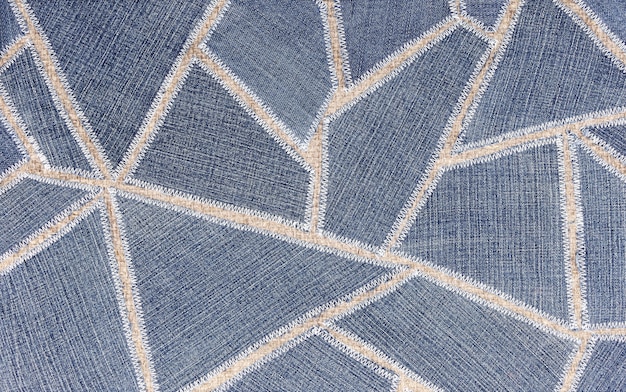 Superfície de textura, costurada a partir de fatias de jeans na tela em formas geométricas