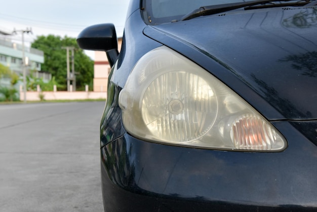 Superficie del faro dañada y borrosa como resultado de las condiciones climáticas y el envejecimiento de un automóvil