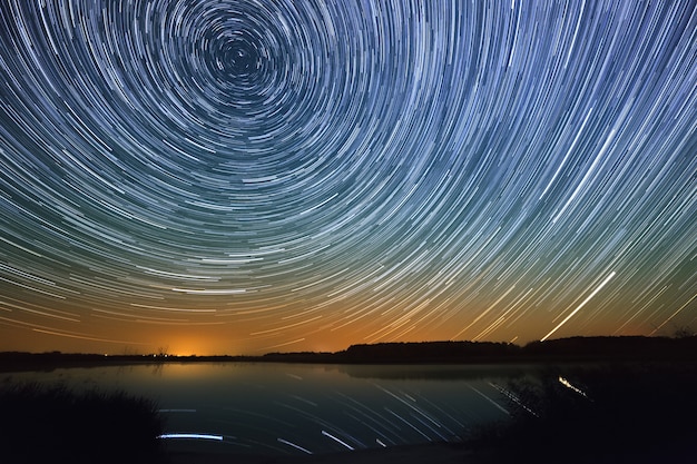 Superfície lisa do lago em um fundo do céu estrelado