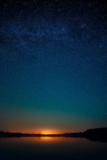 Foto superficie lisa del lago sobre un fondo el cielo estrellado