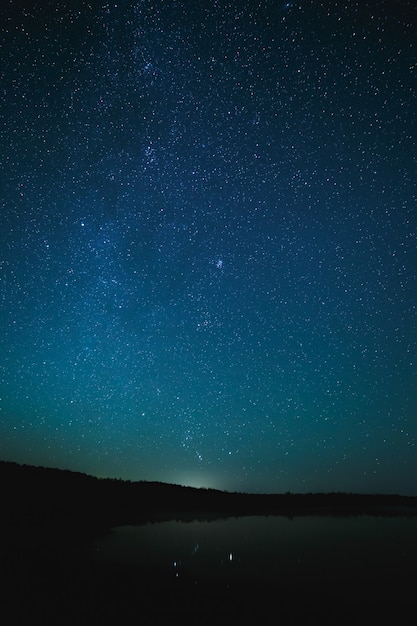 Superficie lisa del lago sobre un fondo el cielo estrellado