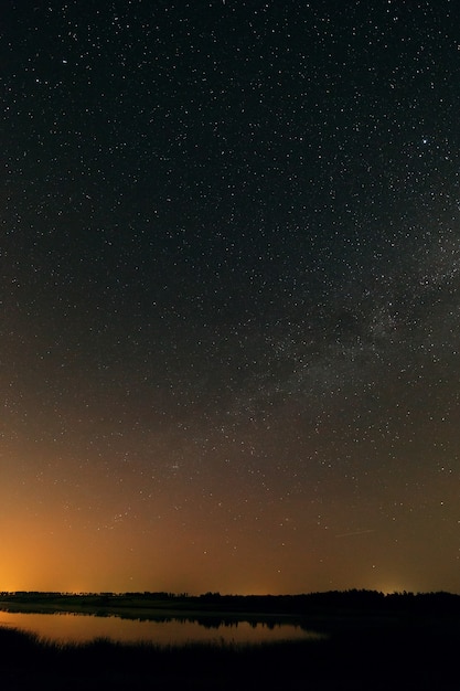 Superficie lisa del lago sobre un fondo el cielo estrellado