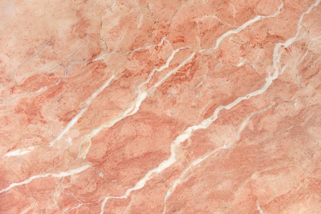 Foto superficie de losa pulida de mármol rosa con vetas blancas
