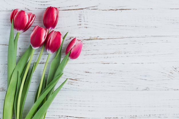 Superficie de madera blanca con tulipanes para el día de la madre