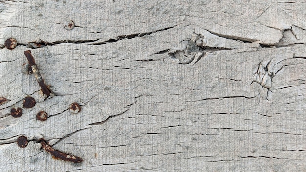 Una superficie de madera con unos clavos y un par de clavos.