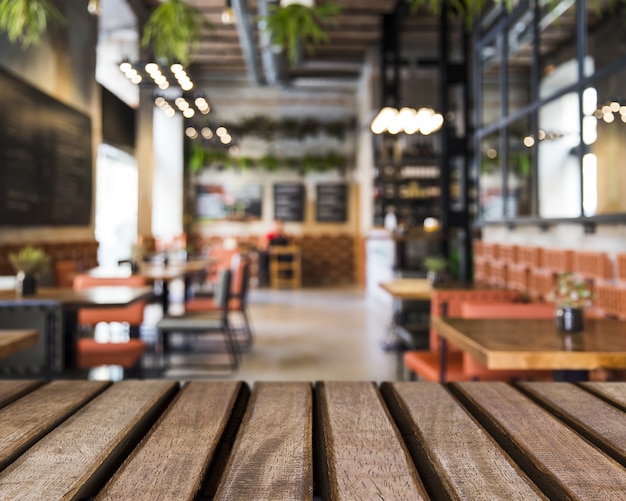 Foto superficie de madera mirando hacia mesa en restaurante