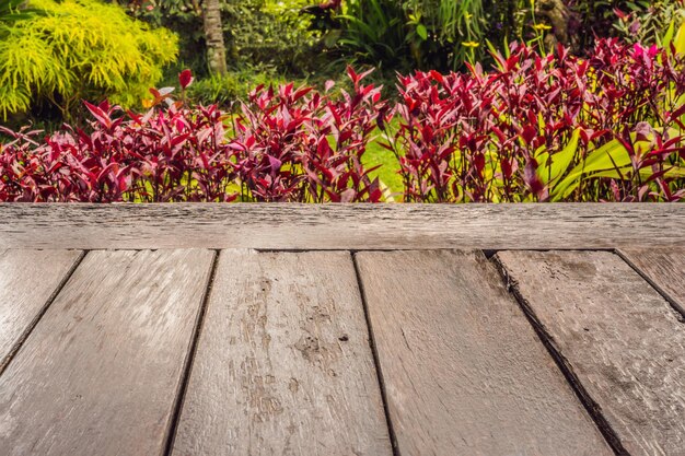 Foto la superficie de la mesa de madera sobre el fondo de las flores.