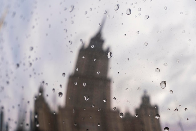 Superficie de metal con gotas de lluvia que reflejan el edificio de gran altura de Moscú. Foto de alta calidad