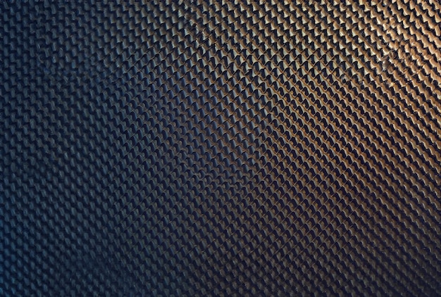 Una superficie metálica de color dorado con un patrón de pequeños puntos.