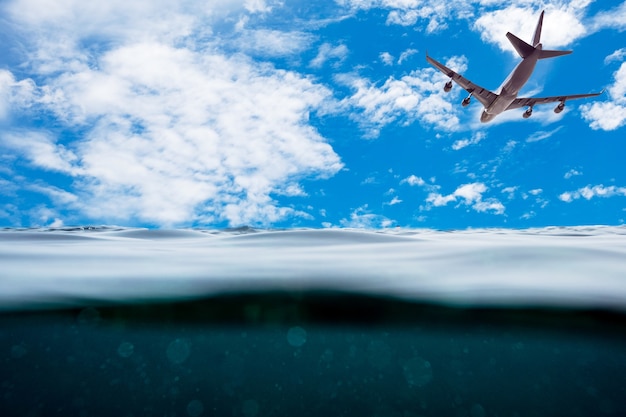 Superficie de la onda submarina con avión en el cielo azul