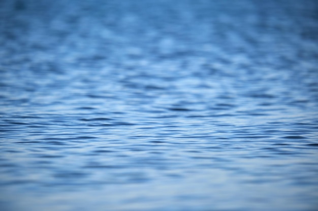 Foto superficie del paisaje marino de primer plano de agua de mar azul con pequeñas ondas onduladas.