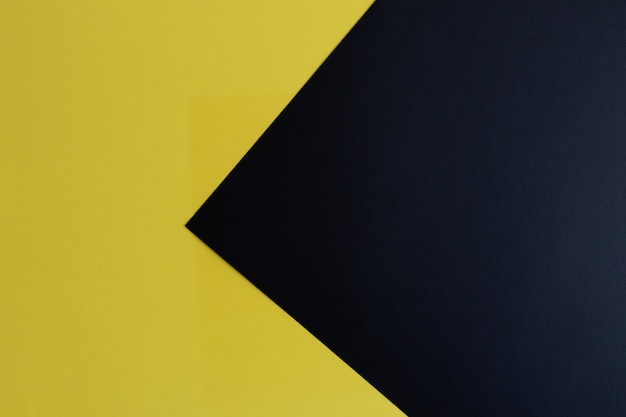 Superficie de papel de color pastel negro y amarillo con espacio para texto