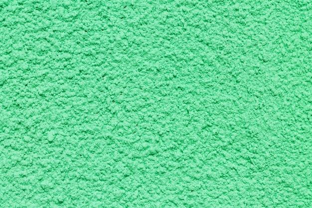 Foto superficie de pared granulada con textura de estuco verde
