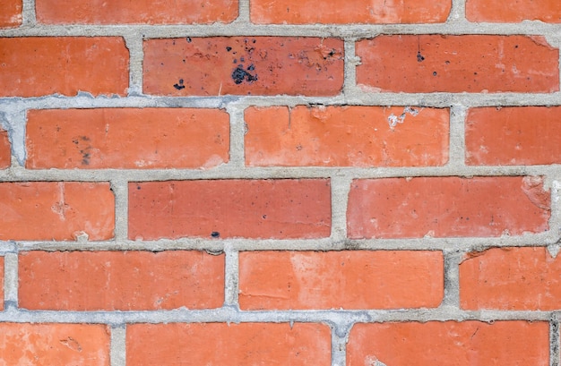 Superficie de pared de ladrillo rojo con junta de cemento visible para el fondo