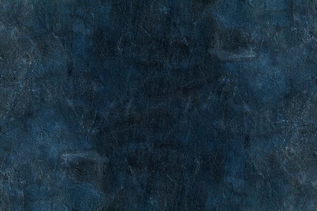 Superficie de pared de piedra envejecida azul oscuro con textura áspera de yeso
