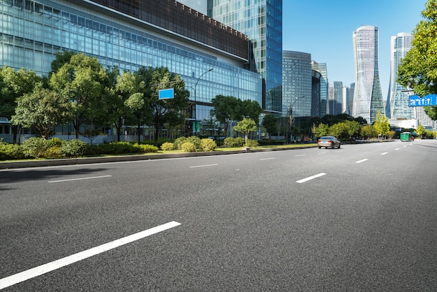 Superficie del piso de la carretera vacía con los edificios emblemáticos de la ciudad moderna de Hangzhou Bund Skyline, Zhejiang, China