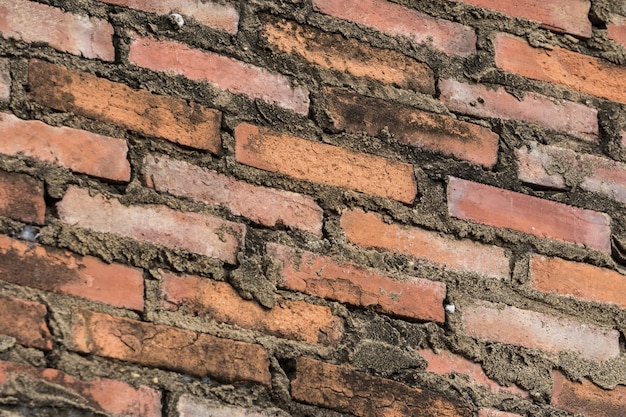 Superficie roja antigua del grunge de la pared de ladrillo vieja con el fondo resistido de la textura del cemento.
