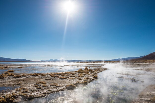 Foto superficie soleada cubierta de vapor y géiseres en bolivia