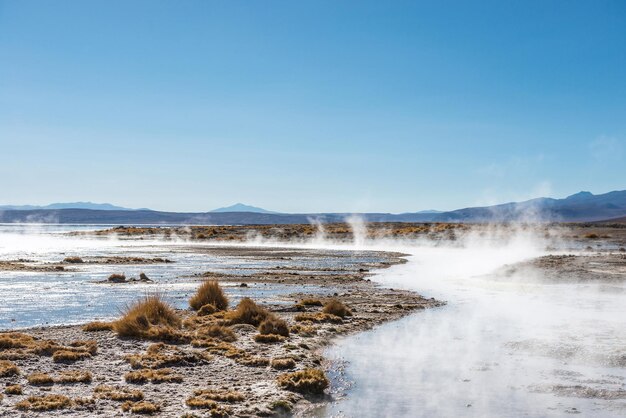 Foto superficie soleada cubierta de vapor y géiseres en bolivia