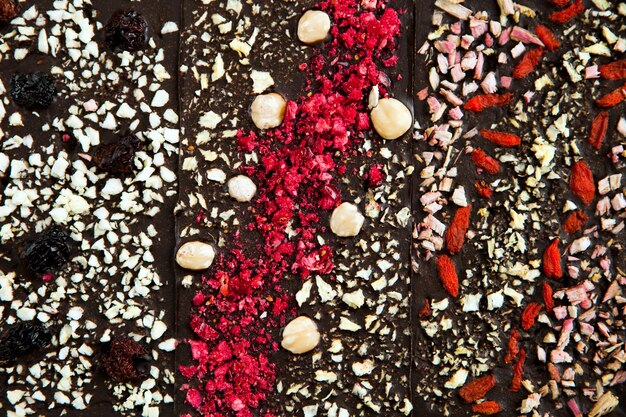 Foto superficies de barras de chocolate oscuro con fondo de nueces desde la vista superior sabroso postre hecho a mano