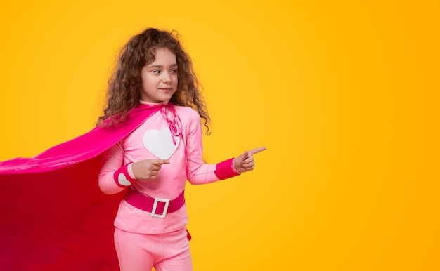Foto superheldenmädchen, das im studio wegzeigt