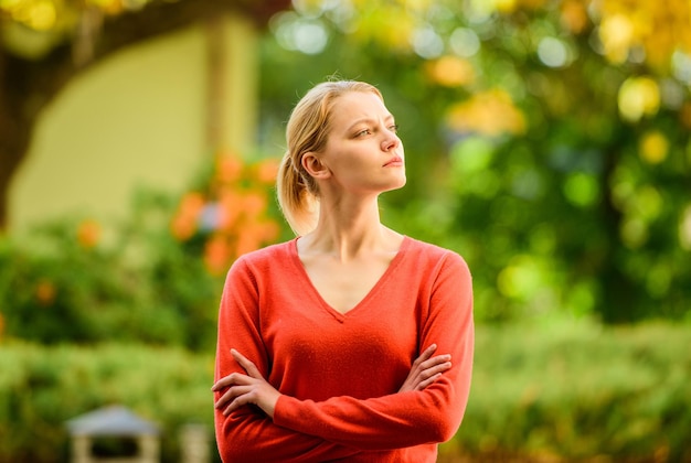 Superior e autoconfiante Mulher elegante e confiante Garota loira sensual ao ar livre fundo da natureza do dia ensolarado Ela está ofendida, mas séria Mulher orgulhosa e confiante cruzou as mãos