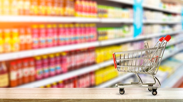 Supermarkt Lebensmitteltisch Hintergrund mit Einkaufswagen Essen und Lebensmittel im Laden verwischt