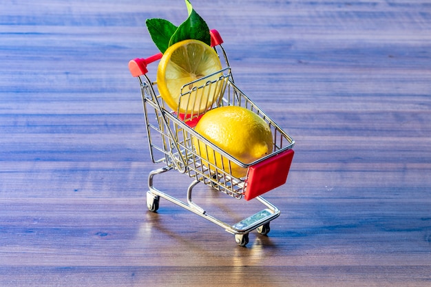 Supermarktwagen mit grünem Blatt und Zitrone