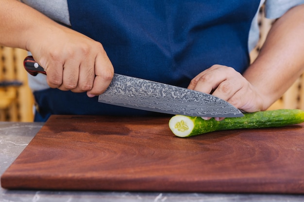 Superscharfes japanisches Küchenmesser schneidet Zucchini in ultradünne Scheiben.