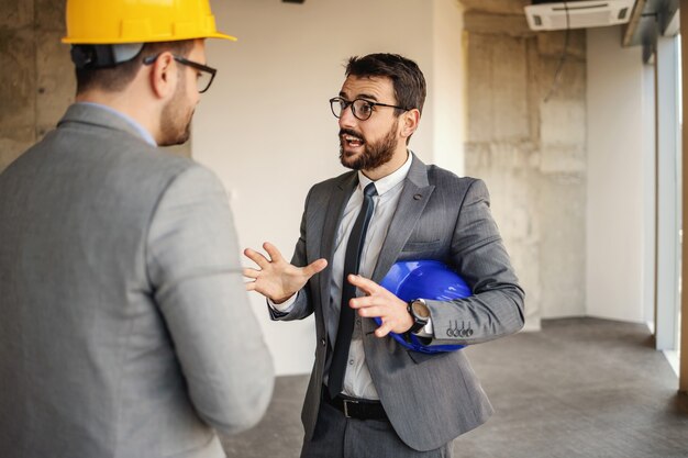 Supervisor conversando com um arquiteto e sugerindo inovações na construção