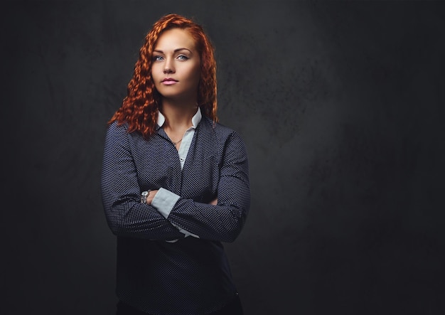 Foto supervisor feminino ruiva vestido com um terno elegante sobre fundo cinza.