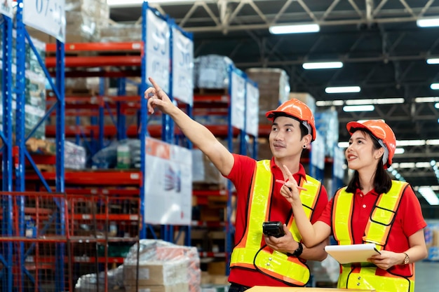 El supervisor y el gerente sonriendo felices sostienen el escáner a mano visitan el almacén como inventario de auditoría anual