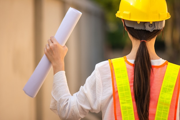 Foto supervisor de mujer traje de seguridad de casco con inspección de planos construcción de inmuebles, mujer trabajadora