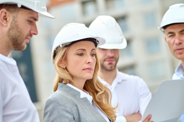 Supervisor rubio concentrado realizando una inspección del sitio de construcción