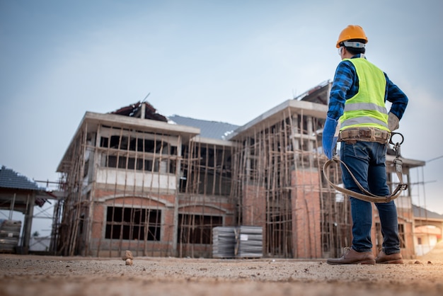 Los supervisores o contratistas asiáticos están observando la construcción de casas grandes o sitios de trabajo en curso.