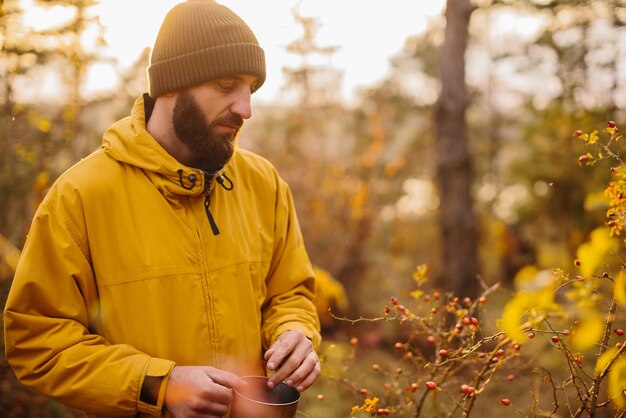 Supervivencia en la naturaleza Un hombre recoge escaramujos en el bosque