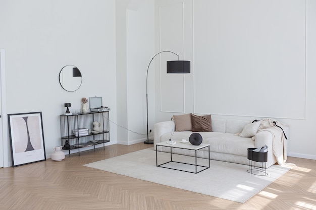 Superweißes, schlichtes, sauberes und stilvolles interieur mit modernen möbeln in nude-farben und kontrastierenden schwarzen elementen, luxuriöses design eines großen, hellen wohnzimmers