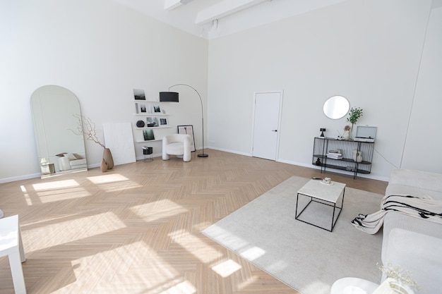 Superweißes, schlichtes, sauberes und stilvolles interieur mit modernen möbeln in nude-farben und kontrastierenden schwarzen elementen, luxuriöses design eines großen, hellen wohnzimmers