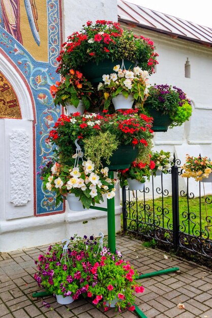 Suporte de ferro com muitos vasos de flores com diferentes flores desabrochando