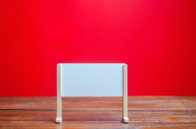 Suporte ou quadro branco sobre um fundo vermelho. Quadro branco vazio. Minimalismo.