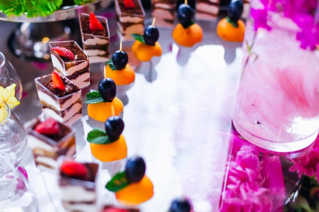 Suporte transparente com cupcakes e frutas recepção de casamento